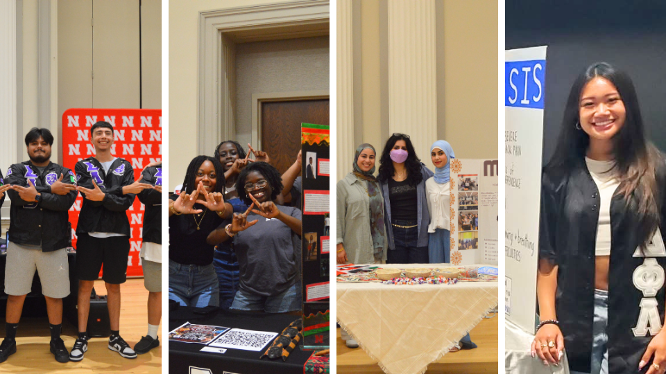 People standing at tables displaying cultural and organizational materials in an indoor event setting.